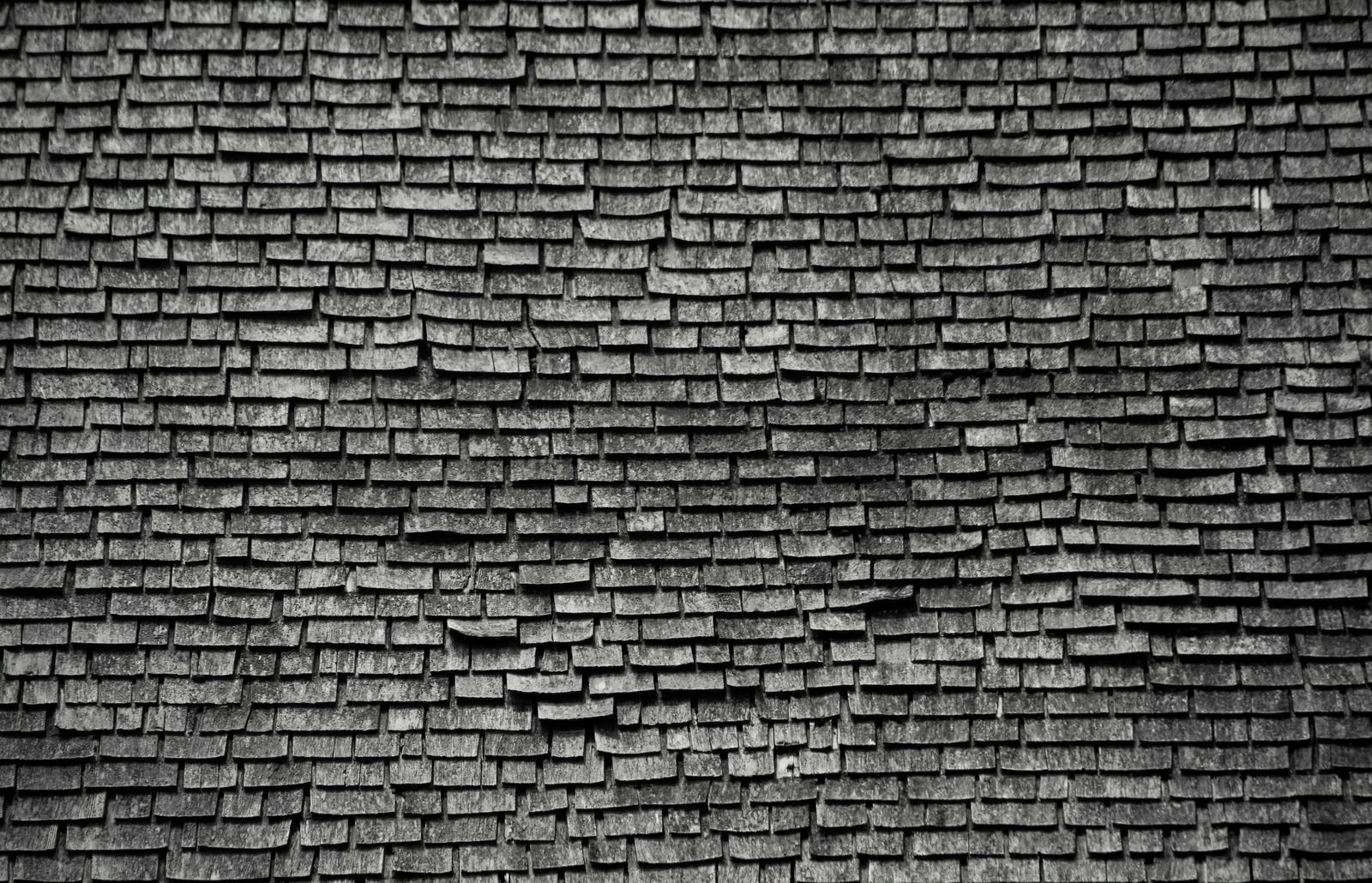 Close-up texture of weathered gray wooden roof shingles