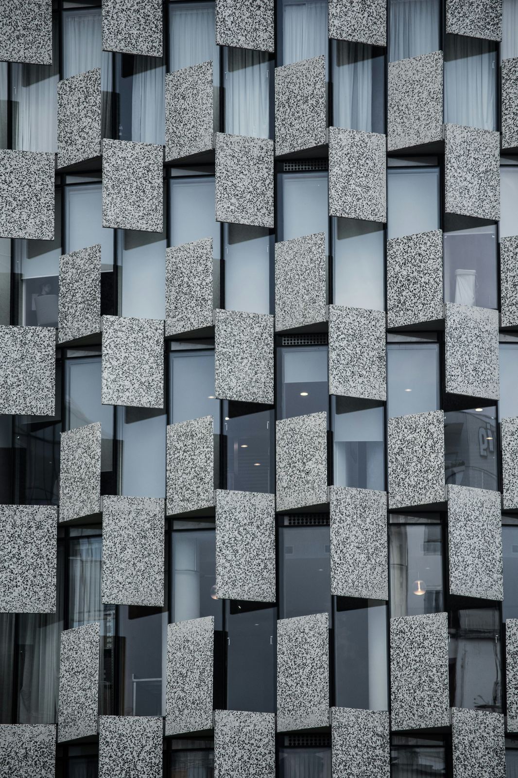 Checkered gray glass and concrete building facade