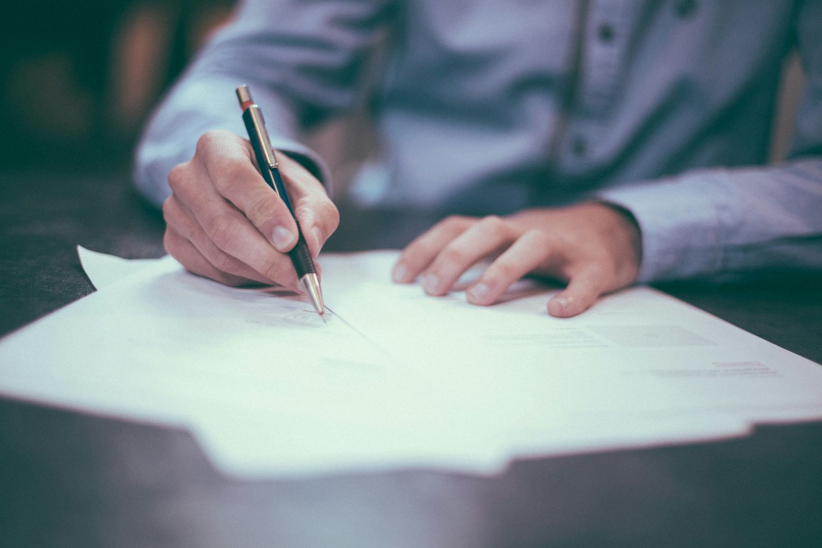 Hand signing a paper document